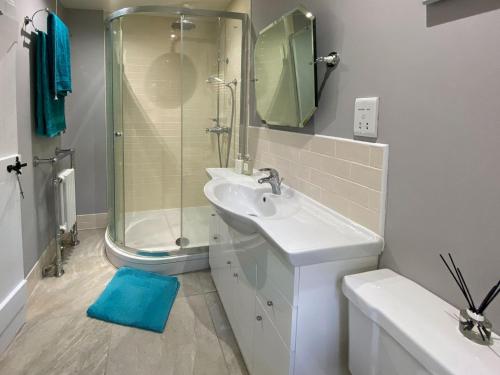 a white bathroom with a sink and a shower at Hoggets Nest in Bedingfield