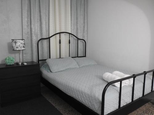a bedroom with a bed with white sheets and a lamp at Casa Del Sol-Unit A in Bayamon