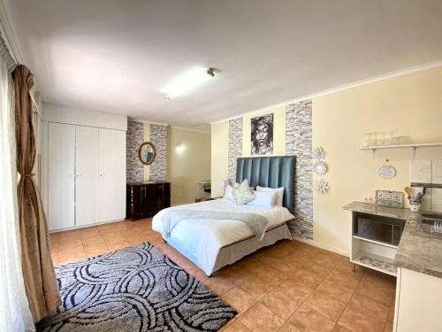 a bedroom with a large bed and a kitchen at MT Perry in Johannesburg