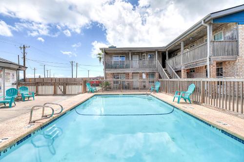 a swimming pool with chairs and a house at Seascape Villas in Padre Island