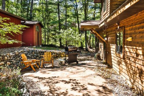 a backyard with a grill and chairs next to a house at The Loons Nest in Eagle River