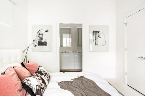 Un dormitorio blanco con una cama y un espejo. en Rooftop Condo, en Nashville