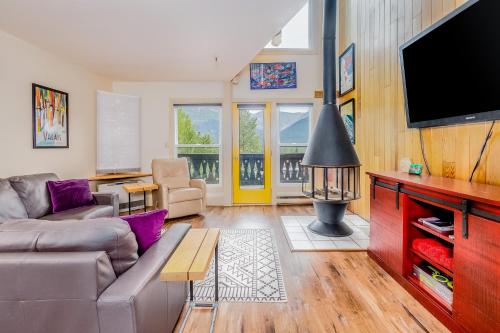 a living room with a couch and a flat screen tv at Mountainside Condo #307 in Girdwood