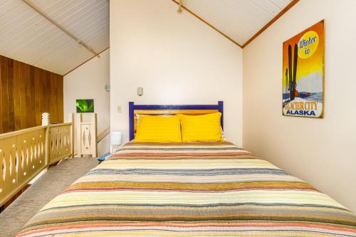 ein Schlafzimmer mit einem großen Bett mit gelben Kissen in der Unterkunft Mountainside Condo #307 in Girdwood