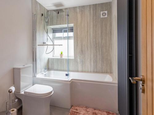 ein Bad mit einer Badewanne, einem WC und einem Fenster in der Unterkunft The Spencer Suite - Uk40476 in Willerby