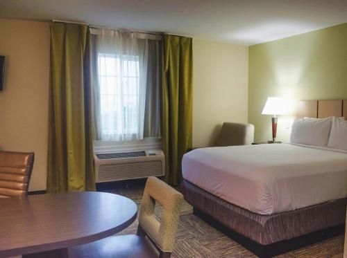 a hotel room with a bed and a table at Candlewood Suites Houston Medical Center, an IHG Hotel in Houston