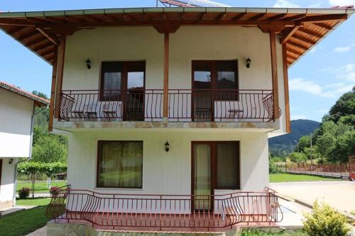 a house with a balcony with chairs on it at By the River Hotel Complex in Balkanets