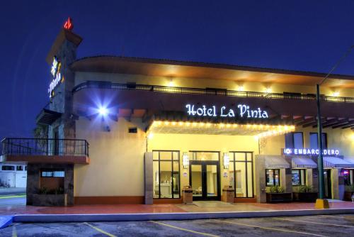 a building with a sign on the side of it at night at La Pinta Hotel in Ensenada