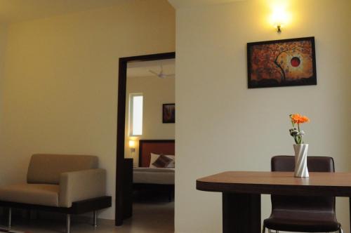 a room with a table and a chair and a mirror at Ixora Suites in Bengaluru