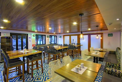 a restaurant with wooden floors and tables and chairs at La Pinta Hotel in Ensenada