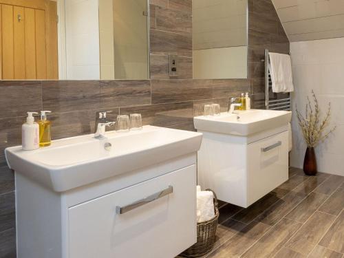 a white bathroom with two sinks and a mirror at Sunset View in Ardmaleish