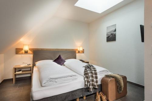 sypialnia z łóżkiem z białą pościelą w obiekcie AlpenParks Hotel & Apartment Central Zell am See w mieście Zell am See
