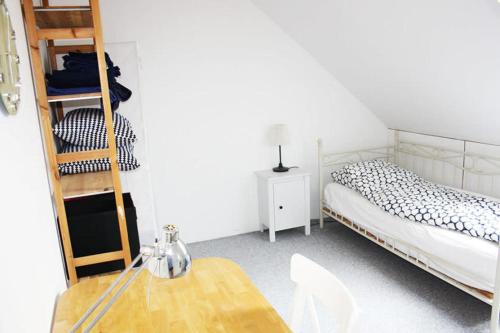 Schlafzimmer mit einem Bett, einem Tisch und einer Leiter in der Unterkunft Dejligt værelse lyst og hyggeligt in Skovlunde