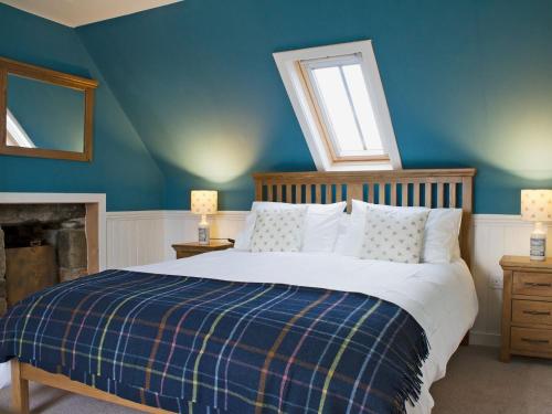 a bedroom with a bed with blue walls and a window at Ethels House in Armadale