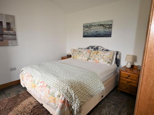 a bedroom with a bed and a wooden nightstand with a bed sidx sidx sidx at Orchard Farm Cottage in Barnby