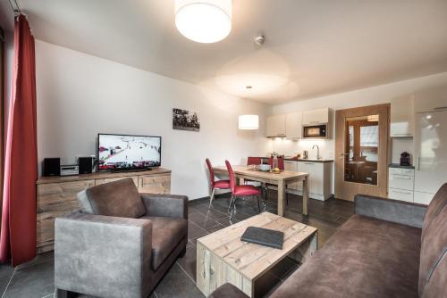 a living room with a couch and a table at AlpenParks Hotel & Apartment Central Zell am See in Zell am See