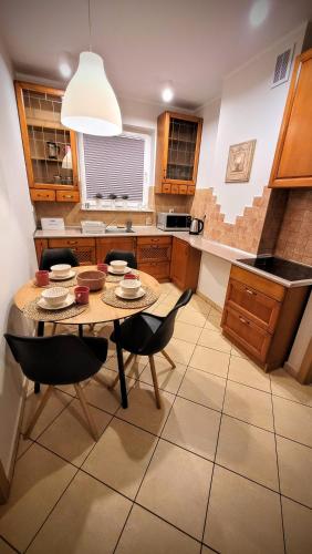 a kitchen with a table and chairs in a room at Apartament DANA piękna plaża wydmy las in Ustka
