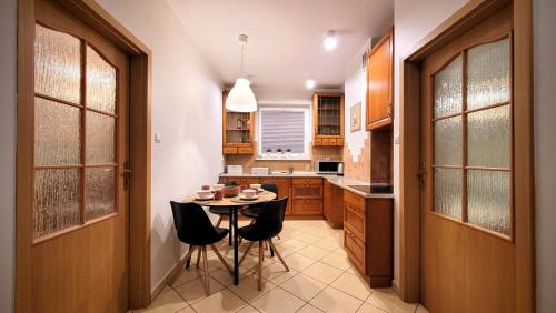 a kitchen with a table and chairs in it at Apartament DANA piękna plaża wydmy las in Ustka