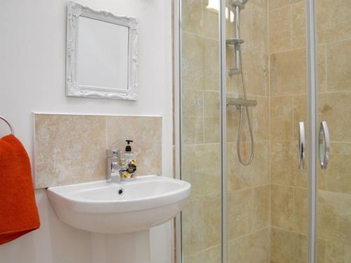 La salle de bains est pourvue d'un lavabo et d'une douche. dans l'établissement Wester Laggan Cottage, à Skye of Curr