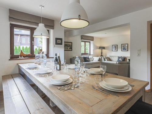Un comedor con una mesa con platos y copas de vino. en Berg und Bach, en Kirchberg in Tirol