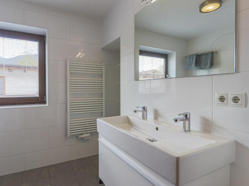 a white bathroom with a sink and a mirror at Berg und Bach in Kirchberg in Tirol