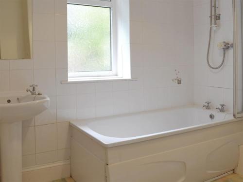 Baño blanco con bañera y lavamanos en Lukesland Farm en Harford
