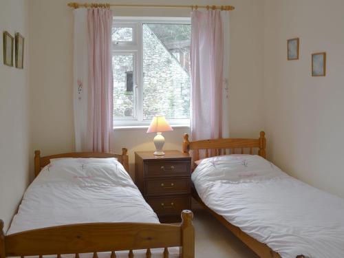 2 łóżka pojedyncze w pokoju z oknem w obiekcie Lukesland Farm w mieście Harford