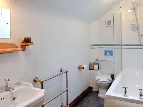 een badkamer met een wastafel, een toilet en een bad bij Spring Cottage in Hollinsclough