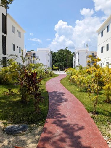 a red brick path in a park with buildings at 2-Bedroom Condo by the Jungle w/ Swimming pool in Puerto Morelos