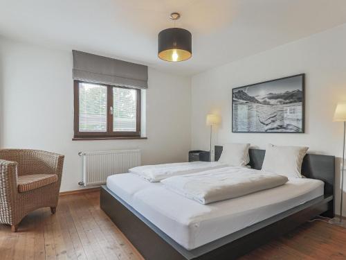 a bedroom with a large bed and a chair at Berg und Bach in Kirchberg in Tirol