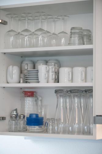 a shelf filled with glasses and cups and dishes at AlpenParks Hotel & Apartment Central Zell am See in Zell am See