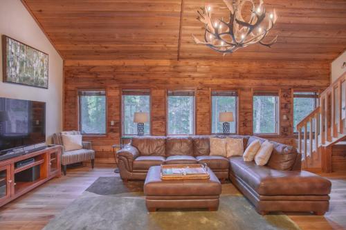 a living room with leather furniture and a chandelier at Aspencliffe Home: Perfect Mountain Getaway w/ Hot Tub in Blue River