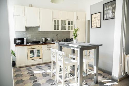uma cozinha com armários brancos e uma mesa e cadeiras em Dob Duplex Apartment em Budapeste