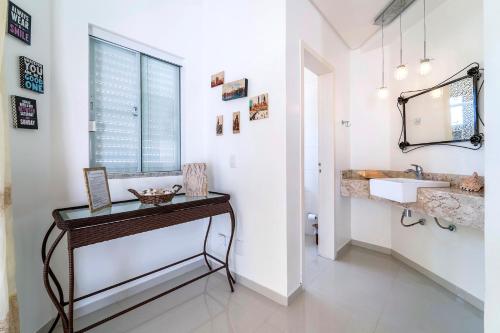 La salle de bains est pourvue d'un lavabo et d'un miroir. dans l'établissement Casa de Praia em Bombinhas Beach House, à Bombinhas