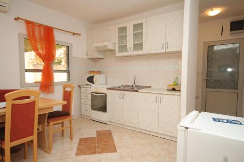 - une cuisine avec des placards blancs, une table et un évier dans l'établissement Apartments by the sea Pasadur, Lastovo - 8391, à Lastovo
