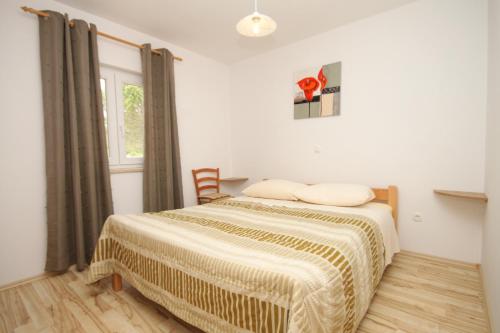 a bedroom with a bed and a window at Apartments with a parking space Trget, Rasa - 7687 in Trget