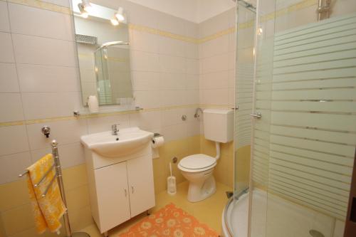 a bathroom with a toilet and a sink and a shower at Apartments with a parking space Trget, Rasa - 7687 in Trget