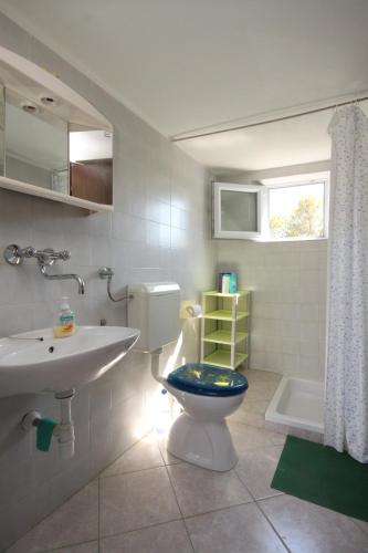 a bathroom with a toilet and a sink and a tub at Secluded fisherman's cottage Lavdara, Dugi otok - 8155 in Sali