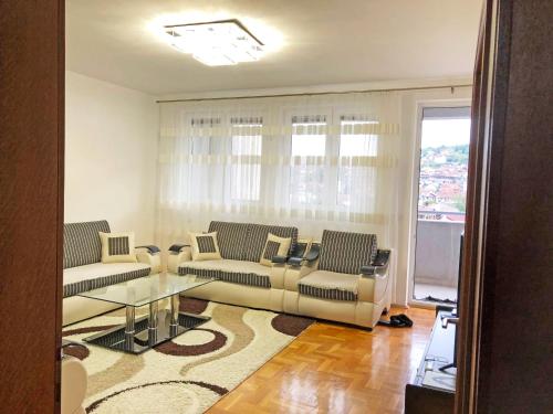 un soggiorno con divani e tavolo in vetro di Central Private Apartment with Views a Pejë