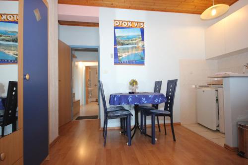 a dining room with a blue table and chairs at Apartments with a parking space Vis - 8869 in Vis