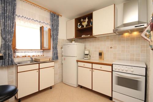 una piccola cucina con elettrodomestici bianchi e una finestra di Apartments with a parking space Sali, Dugi otok - 8084 a Sali (Sale)
