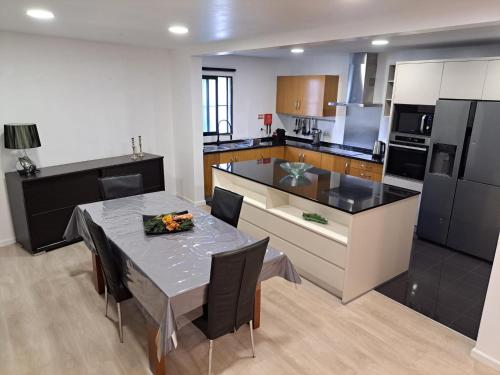 a kitchen with a table and a kitchen with black appliances at Friendly house in Funchal