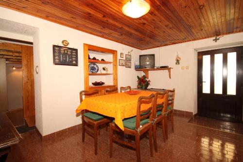 ein Esszimmer mit einem gelben Tisch und Stühlen in der Unterkunft Seaside holiday house Miholascica, Cres - 8073 in Martinšćica