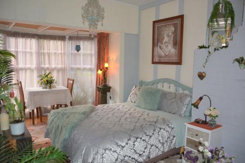 a bedroom with a bed and a table and a window at Enchanted Escape in Picton