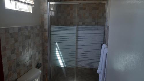 a shower with a glass door in a bathroom at Chillinn at duke in Kingston