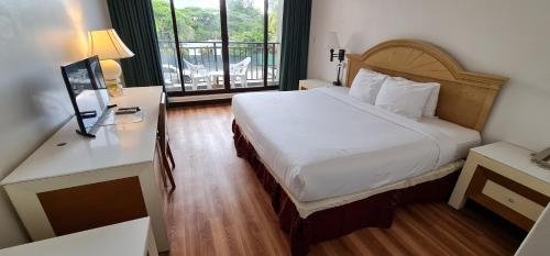 um quarto de hotel com uma cama e uma varanda em SureStay Hotel by Best Western Guam Airport South em Tamuning