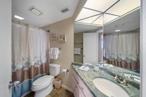 ein Badezimmer mit einem Waschbecken, einem WC und einem Spiegel in der Unterkunft Summer House 1006a condo in Orange Beach