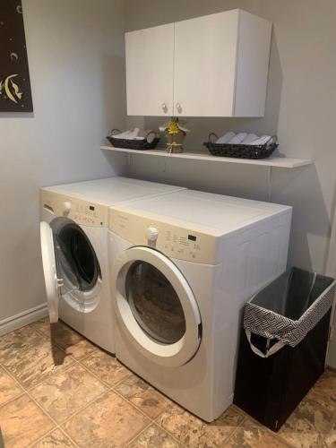 uma máquina de lavar e secar roupa branca num quarto em Aux quatre vents 3,5 logement intime et privé em Lac-Mégantic