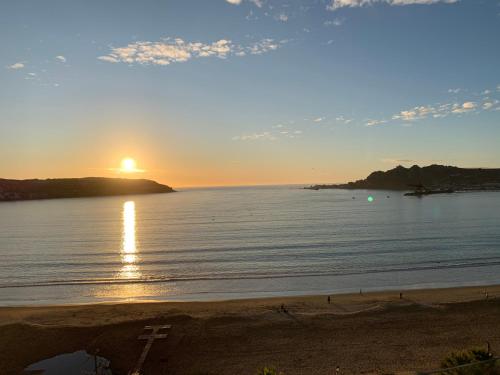 a sunset over the ocean with a cross on the beach at Departamento Playa Herradura in Coquimbo
