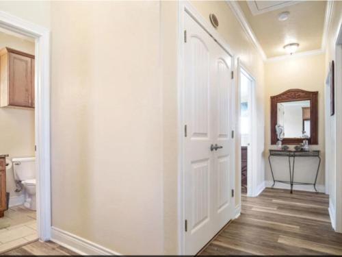 a hallway with a white door in a bathroom at Fancy Nancy 2 Min Walk to Beach, Lyft, Pet-friendly in Bolivar Peninsula